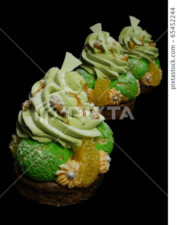 Choux pastry desserts with oranges, pistachio ganache and white chocolate decorations Choux pastry desserts with oranges, pistachio ganache and white chocolate decorations 65452244