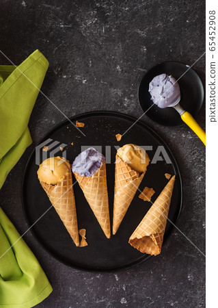 Refreshing yellow and violet ice cream cones on Refreshing yellow and violet ice cream cones on 65452908