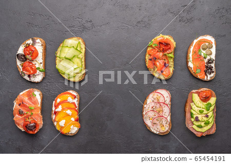 Homemade sandwiches with bread and various ingredients and spices on a dark background. Healthy 65454191