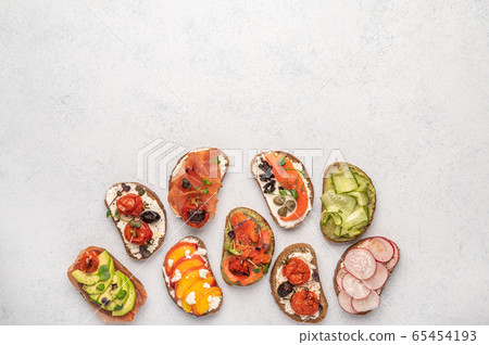 Homemade sandwiches with bread and various ingredients and spices on a light background. Healthy 65454193