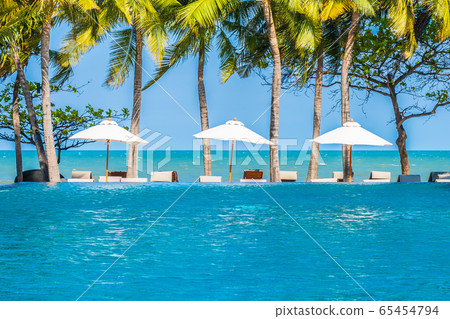 Umbrella and chair around swimming pool in hotel resort neary sea ocean beach for vacation Umbrella and chair around swimming pool in hotel resort neary sea ocean beach for vacation 65454794
