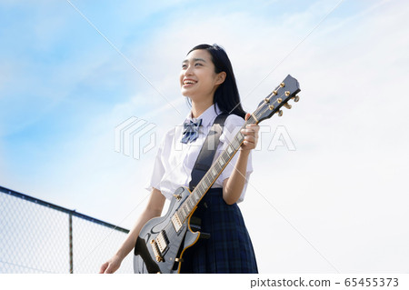 Schoolgirl looking up at the sky on the roof Schoolgirl looking up at the sky on the roof 65455373