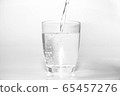 bright water dripping into the glass with many bubble in water bright blue background . healthcare drinking advertising concept  65457276