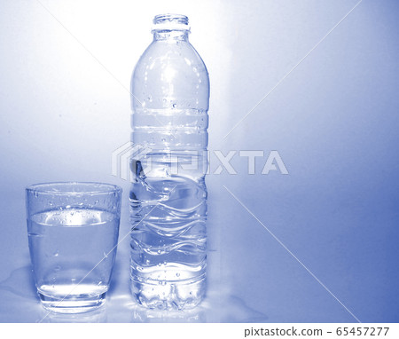 blue fresh water in plastic bottle and full water in glass bright blue background . drinking healthcare concept . blue fresh water in plastic bottle and full water in glass bright blue background . drinking healthcare concept . 65457277
