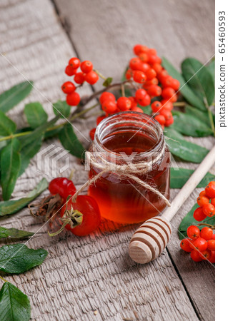 Fresh rose hip berries, rowan and honey on wooden 65460593
