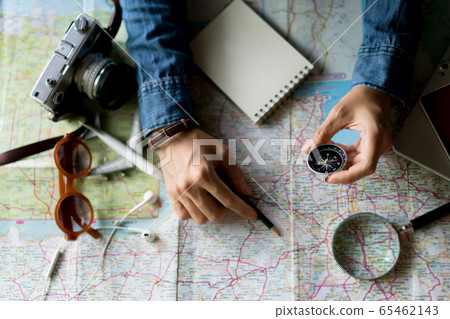 Hand holding compass for planning vacation trip 65462143