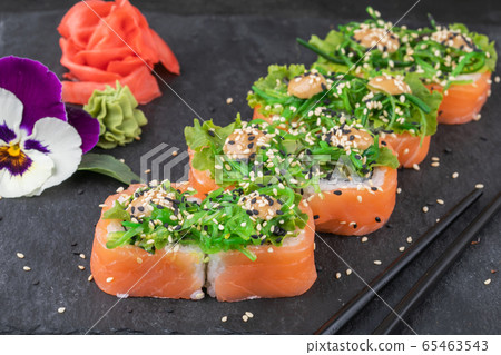 Sushi rolls with seafood and Chuka salad. Green sushi. Top view. Free space for your text. Sushi rolls with seafood and Chuka salad. Green sushi. Top view. Free space for your text. 65463543