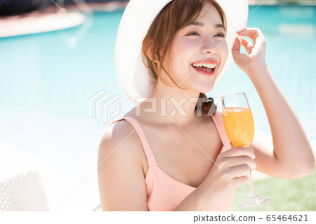 年輕女子在游泳池旁享受度假之旅 65464621