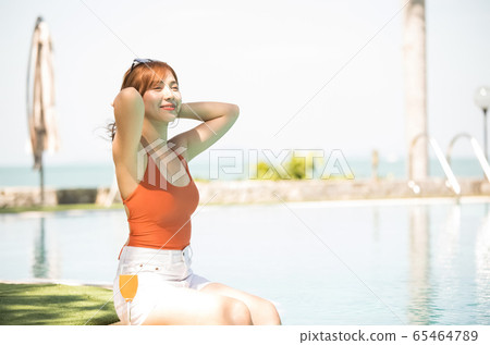 A woman in a swimsuit enjoying a resort trip 65464789
