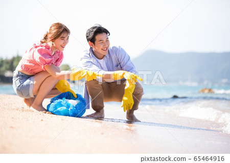 Men and women doing beach clean 65464916