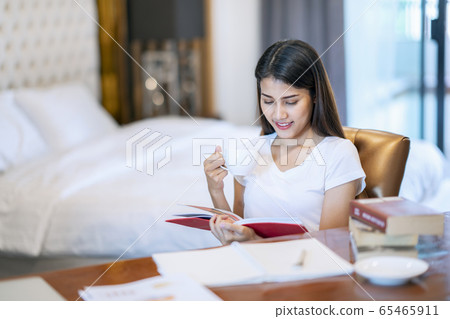 Asian student do a home work in her bed room Asian student do a home work in her bed room 65465911