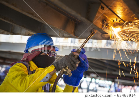 Worker is cutting manually old metal construction 65465914