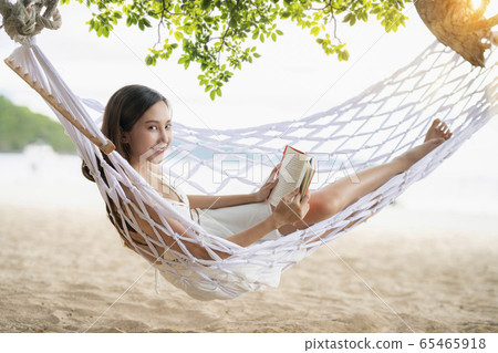 Asian Woman lying in a hammock on the beach Asian Woman lying in a hammock on the beach 65465918