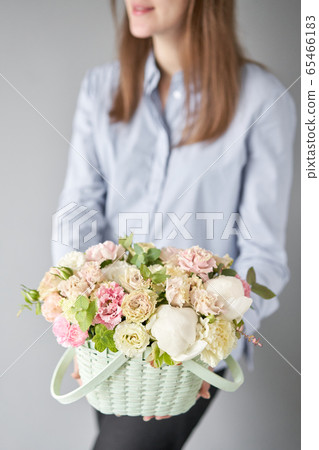 Small flower shop and Flowers delivery. Flower arrangement in Wicker basket. Beautiful bouquet of mixed flowers in woman hand. Handsome fresh bouquet. Small flower shop and Flowers delivery. Flower arrangement in Wicker basket. Beautiful bouquet of mixed flowers in woman hand. Handsome fresh bouquet. 65466183