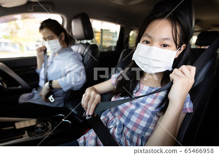 Mother and daughter fastening seat belt,woman sit in a car put on her seat belt for driving safety,child girl wearing a protective mask during the Coronavirus pandemic,spread of Covid-19,Protection Mother and daughter fastening seat belt,woman sit in a car put on her seat belt for driving safety,child girl wearing a protective mask during the Coronavirus pandemic,spread of Covid-19,Protection 65466958