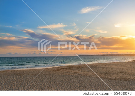 Landscape of beautiful sunset on the ocean, with sand, horizon with a blue sky. Portugal. Landscape of beautiful sunset on the ocean, with sand, horizon with a blue sky. Portugal. 65468073