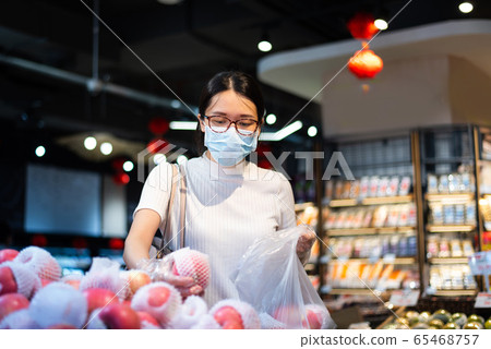 Asian woman shopping for fruit in the market Asian woman shopping for fruit in the market 65468757