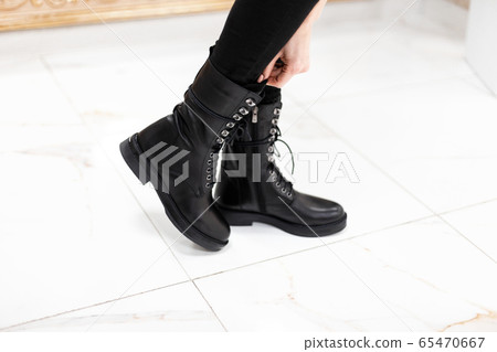 Female legs in fashionable leather black boots 65470667