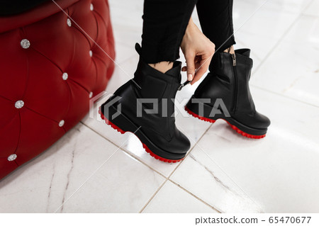 Female legs in fashionable leather black boots 65470677