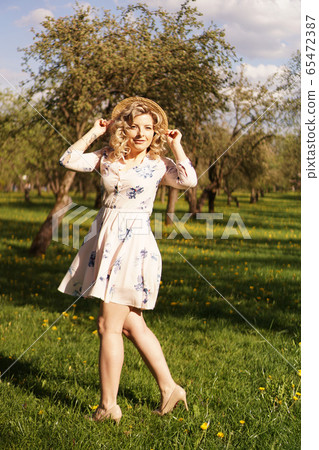 Smiling summer woman with straw hat in park Smiling summer woman with straw hat in park 65472387