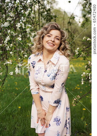 Beautiful young woman in apple garden in spring sunny day Beautiful young woman in apple garden in spring sunny day 65472480