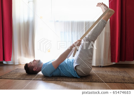Caucasian man in yoga pose laying on back with Caucasian man in yoga pose laying on back with 65474683
