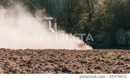 In the spring, a farmer pulls harrows with a In the spring, a farmer pulls harrows with a 65479032