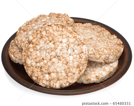 Puffed rice bread in a plate isolated on white background, diet crispy round rice waffles Puffed rice bread in a plate isolated on white background, diet crispy round rice waffles 65480331