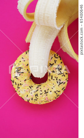 Sweet donut and banana on pink color background. Erotic concept 65480646