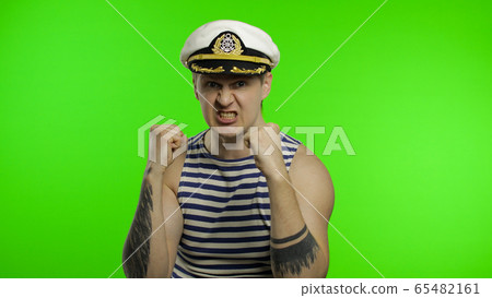 Young sailor man is angry and shows fists. Seaman guy in sailor's vest 65482161