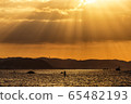 The sky that shines beautifully in twilight rays, the shining coast, fishing boats, and surfers 65482193