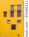 Warm yellow facade with rustic windows 65490311