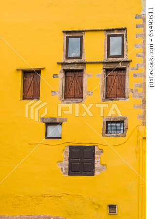 Warm yellow facade with rustic windows 65490311