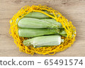 Mature corn on the cob in a cotton mesh bag wooden background top view 65491574