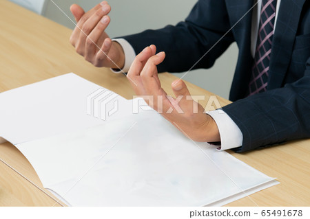 A businessman using gestures to explain a pamphlet to a customer Business negotiation A businessman using gestures to explain a pamphlet to a customer Business negotiation 65491678
