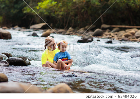 Mother and child swimming in mountain river. 65494020