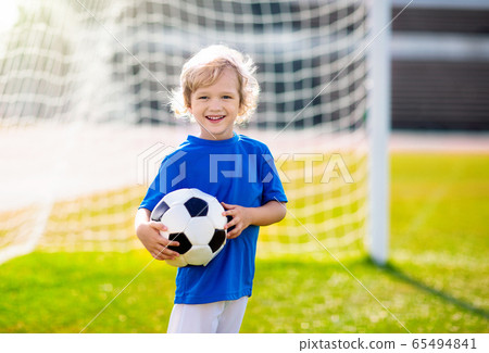 Kids play football. Child at soccer field. Kids play football. Child at soccer field. 65494841