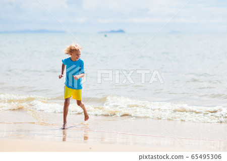 Kids playing on beach. Children play at sea. 65495306