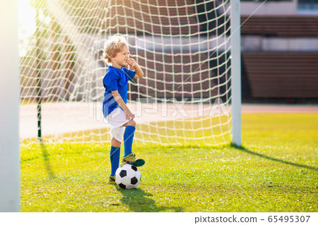 Kids play football. Child at soccer field. 65495307