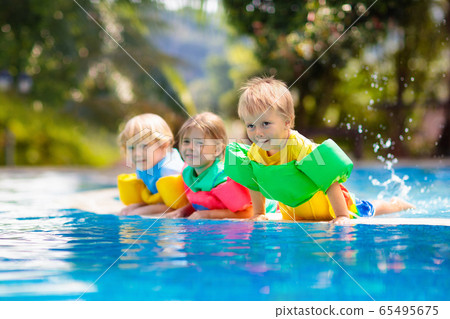 Kids in swimming pool. Life jacket for child. 65495675