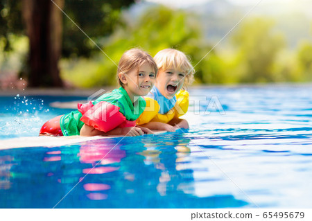 Kids in swimming pool. Life jacket for child. Kids in swimming pool. Life jacket for child. 65495679