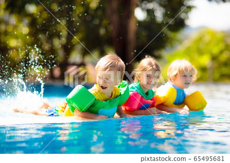 Kids in swimming pool. Life jacket for child. 65495681