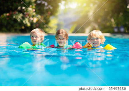 Kids in swimming pool. Life jacket for child. Kids in swimming pool. Life jacket for child. 65495686