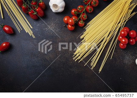 spaghetti, tomato and garlic on the black table spaghetti, tomato and garlic on the black table 65495737