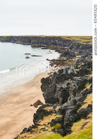 Aerial view of black volcanic rocky shore in cloudy cold weather. Discovering wild nature, traveling around Iceland or Norway Aerial view of black volcanic rocky shore in cloudy cold weather. Discovering wild nature, traveling around Iceland or Norway 65495820