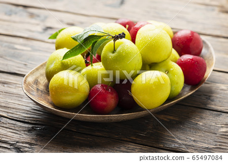 Fresh sweet plums on the wooden table Fresh sweet plums on the wooden table 65497084