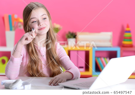 Portrait of cute girl using laptop at desk 65497547