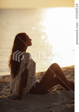 Woman Resting on the Beach During Vacations Woman Resting on the Beach During Vacations 65500529