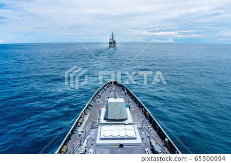Navy modern stealth frigate sail along the calm sea behide the cruiser type warship,view from bow. 65500994