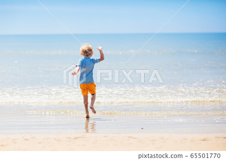 Kids playing on beach. Children play at sea. 65501770